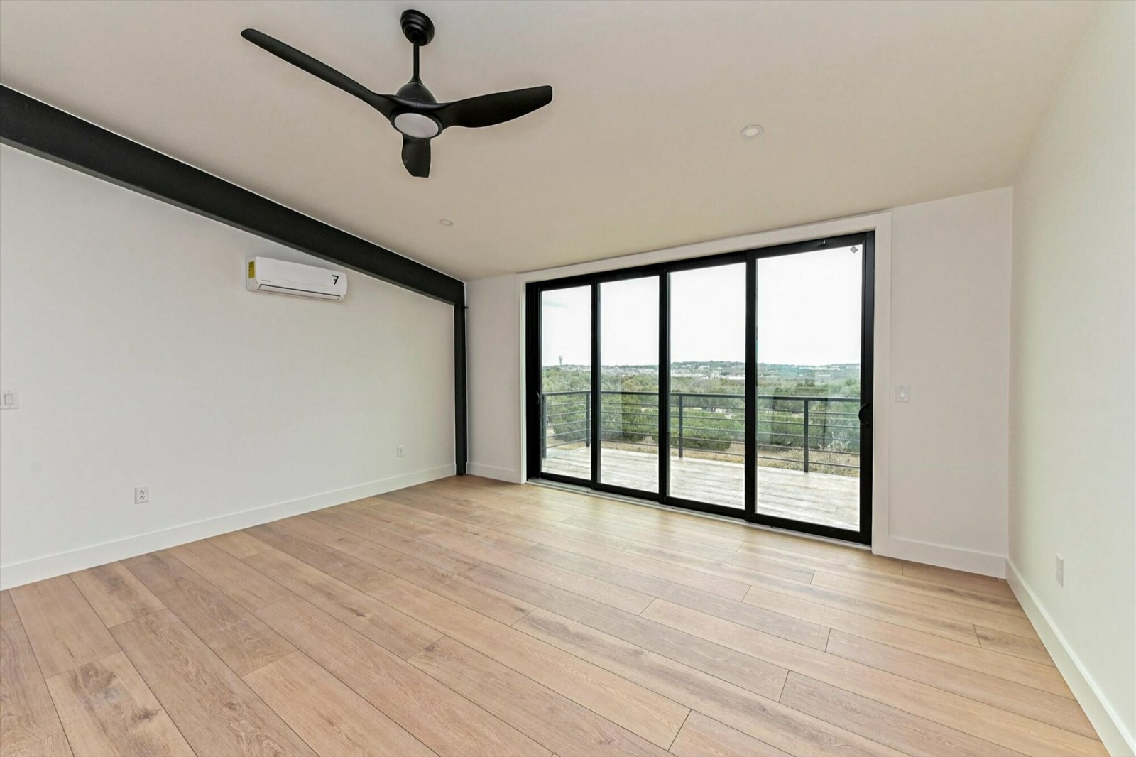 Finished interior of a Farm Lane unit with wood floors, large windows, and balcony access