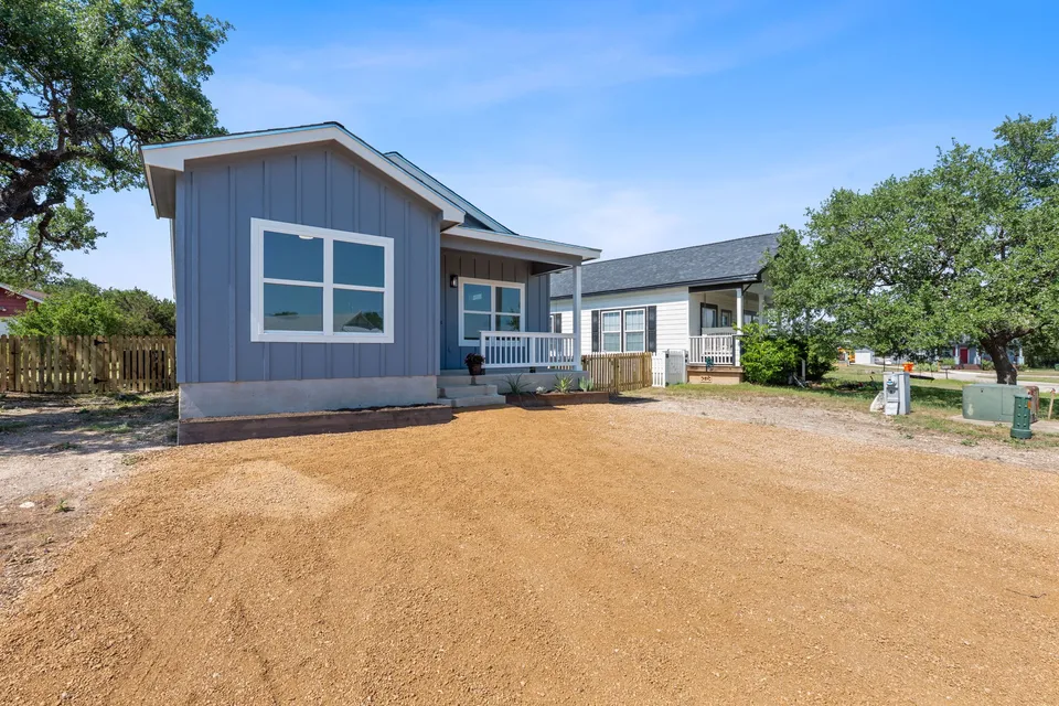 Newly built single-family home with board-and-batten siding and a covered porch in the Texas Hill Country